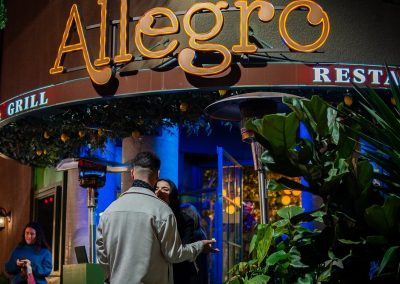 couple talking to each other in front of allegro's outdoor sign